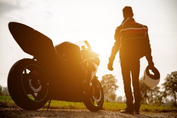 motociclista e la sua moto durante il tramonto